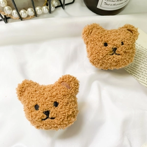 Detail of plush brown bear phone grips with curly faux fur texture and cute embroidery