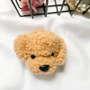 Close-up of a cute brown plush teddy dog phone grip with curly faux fur texture
