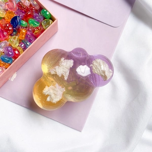 Close-up of cloud shaped phone grip with purple yellow gradient and gold glitter