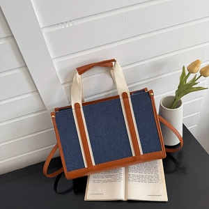 Deep blue denim and brown leather patchwork tote bag with stylish top handle and strap
