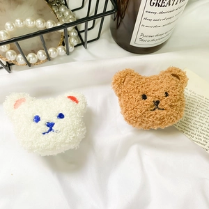 Close-up detail of plush bear phone sockets in curly fleece with soft embroidery