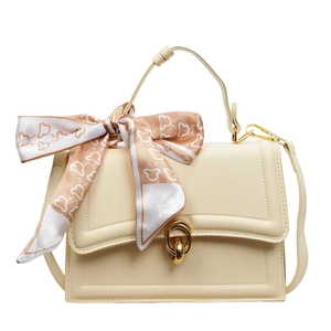 Cream vintage handbag with golden oval lock and decorative silk scarf accessory