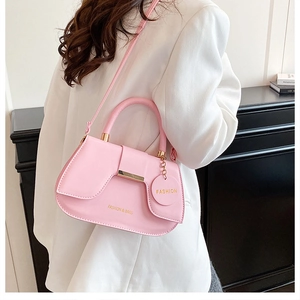 Pink saddle bag with gold buckle and fashion engraving shown on model in home setting