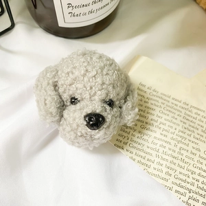 Detailed view of the plush grey teddy dog phone socket on white fabric background