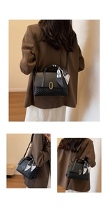 Detail of black woven patchwork handbag with gold clasp and decorative silk scarf