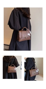Detail of a brown woven leather handbag featuring a gold U-shaped clasp and silk scarf