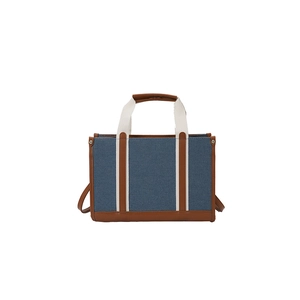 Blue canvas tote bag with brown leather trim and wide straps for shoulder and crossbody use
