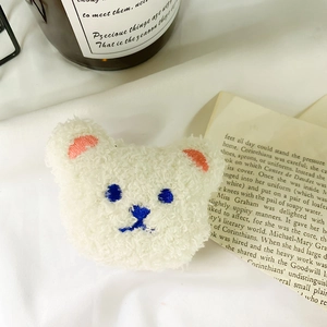 Close-up detail of cute cream plush bear phone socket with soft lamb wool texture