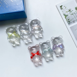 Détail des supports de téléphone ours transparents avec nœuds colorés sur boîte cadeau