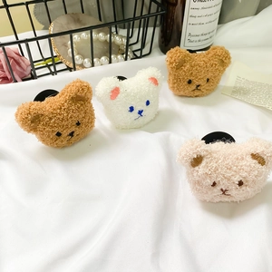Detail of four colorful plush teddy bear phone grips with curly faux fur and embroidery