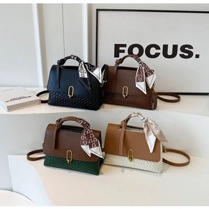 Detail of four stylish handbags with woven texture, metal buckles and silk scarf handles