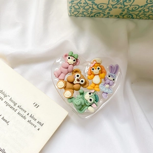Detail view of five cartoon resin animal figures inside a heart-shaped transparent case