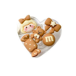 Heart-shaped phone grip with cartoon bear, girl, and candy beans in brown and beige tones