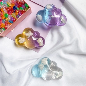 Glittery cloud phone grip sockets in various colors on a soft aesthetic background