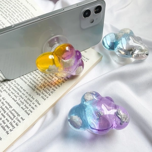 Glitter cloud phone socket grip with colorful gradient resin design on a smartphone