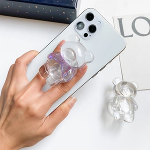 Gros plan d'un support de téléphone ours transparent avec nœud papillon iridescent