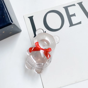 Support de téléphone ours en acrylique avec nœud rouge sur fond de boîte cadeau élégante