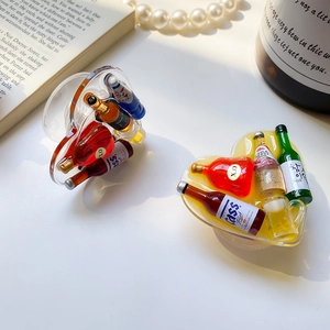 Macro shot of two heart-shaped resin phone grips with miniature beverage bottles inside