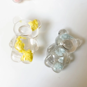 Gros plan de supports de téléphone ours avec garnissage en fibres jaunes et bleu clair