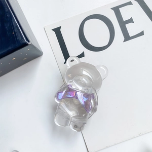 Gros plan d'un support de téléphone ours en résine avec un nœud violet irisé