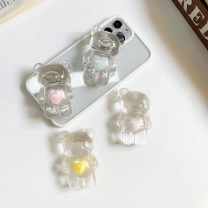 Close-up of clear resin bear phone socket with plush heart inlay on a smartphone back