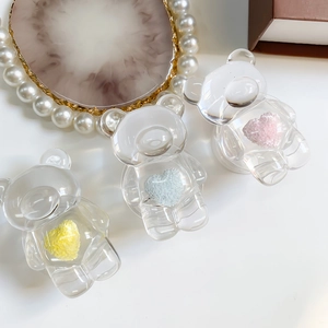 Detailed view of bear-shaped phone grips with colorful hearts in pink, blue, and yellow