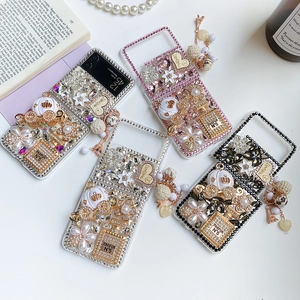 Detail view of rhinestone fold phone cases with luxury perfume bottle charms and pearls