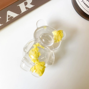 Détail d'un support de téléphone en forme d'ours transparent avec rembourrage jaune