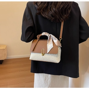 Detailed view of women's woven handbag featuring brown leather flap and silk scarf handle
