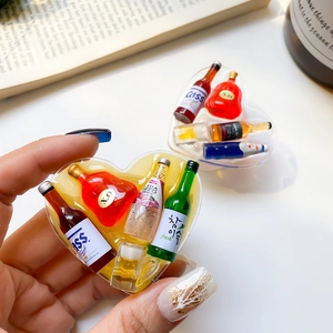 Close-up of heart-shaped resin phone grip with tiny miniature beer and liquor bottles