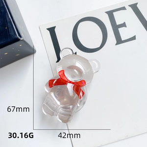 Détail du support téléphone ours transparent avec nœud rouge, hauteur 67mm et largeur 42mm