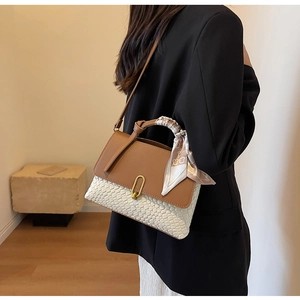 Detail of elegant two-tone handbag with metal U-buckle and floral scarf handle