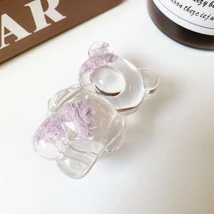 Gros plan détaillé du support de téléphone transparent en forme d'ours avec fourrure mauve