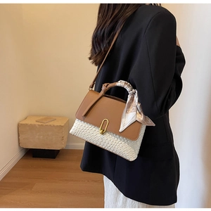 Detailed back view of a woven leather tote bag with a silk scarf handle and metal clasp