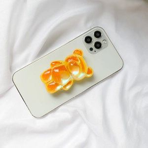 Détail macro du support de téléphone ours 3D orange avec finition holographique sur mobile