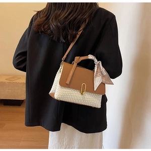 Detail of woven crossbody bag with brown leather flap and silk scarf handle decor