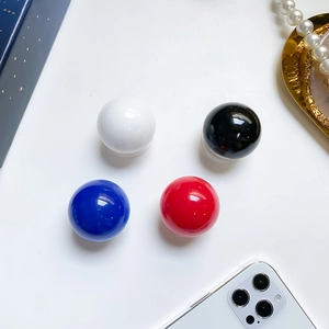 Close-up of glossy crystal ball phone grip stand in red blue black and white colors