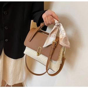 Detail of woven patchwork handbag with brown leather flap and decorative silk scarf wrap