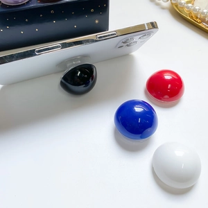 Top view of glossy round phone socket stands in black, red, blue, and white colors