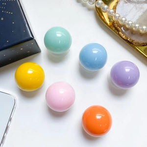 Close-up of colorful crystal ball phone grips in assorted pastel shades on white surface