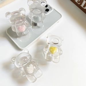 Transparent bear phone grip with colorful plush heart inserts on a white smartphone