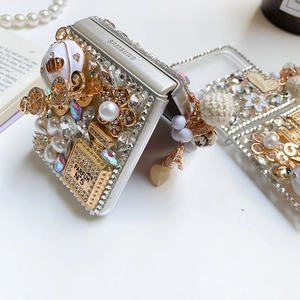 Detail view of champagne gold Samsung Z Flip case with rhinestones and perfume bottle charm