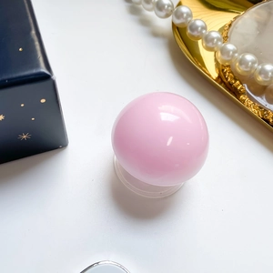 Detailed view of a pink spherical grip with a transparent suction base on a white background