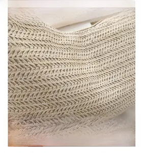 Détail macro du sac à main en paille beige montrant le tissage premium en forme de V