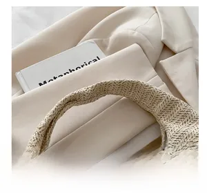 Gros plan sur la texture en paille tissée et les poignées de ce sac à main beige chic