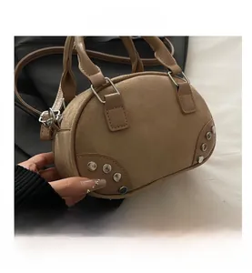 Detailed macro view of silver rivet accents on brown suede retro bowling bag surface