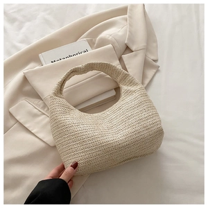 Detail of cream woven handbag showing fine twill texture and minimalist top handle design