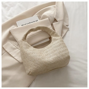 Detail of woven beige hobo bag with herringbone pattern on a minimalist blazer