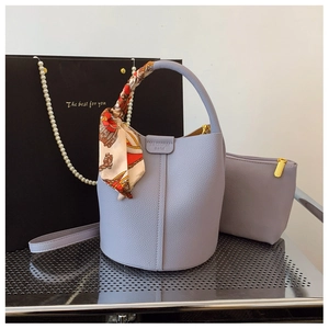 Close-up of lilac lychee texture leather bucket bag with silk scarf and matching pouch