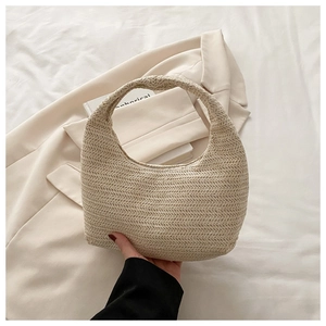 Detailed view of beige woven half-moon handbag with minimalist textured weave and strap